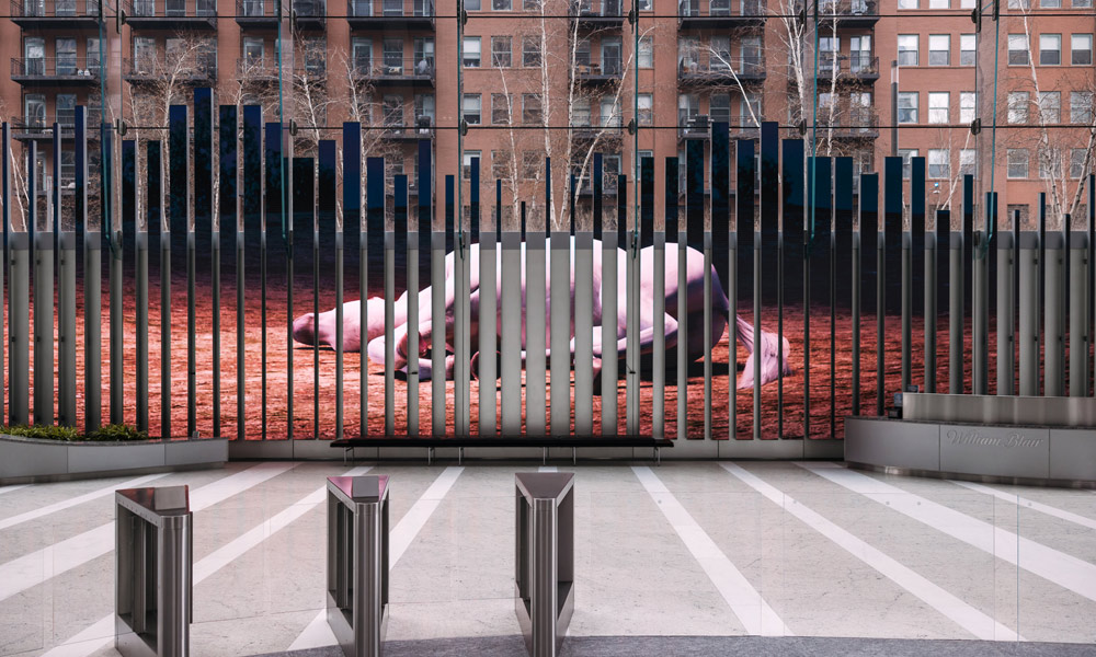 A large LED art installation in a public space, showing a still from the immersive video installation unicorn in the garden by jonathan monaghan