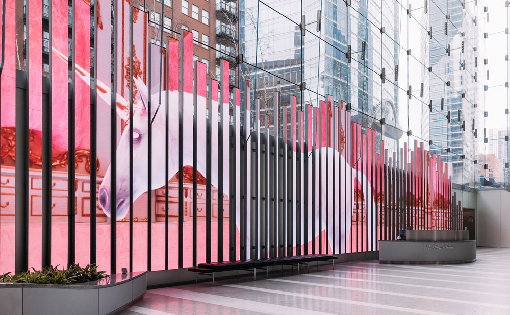 a photo of the immersive LED video installation in action, with the unicorn towering over a crowd of onlookers