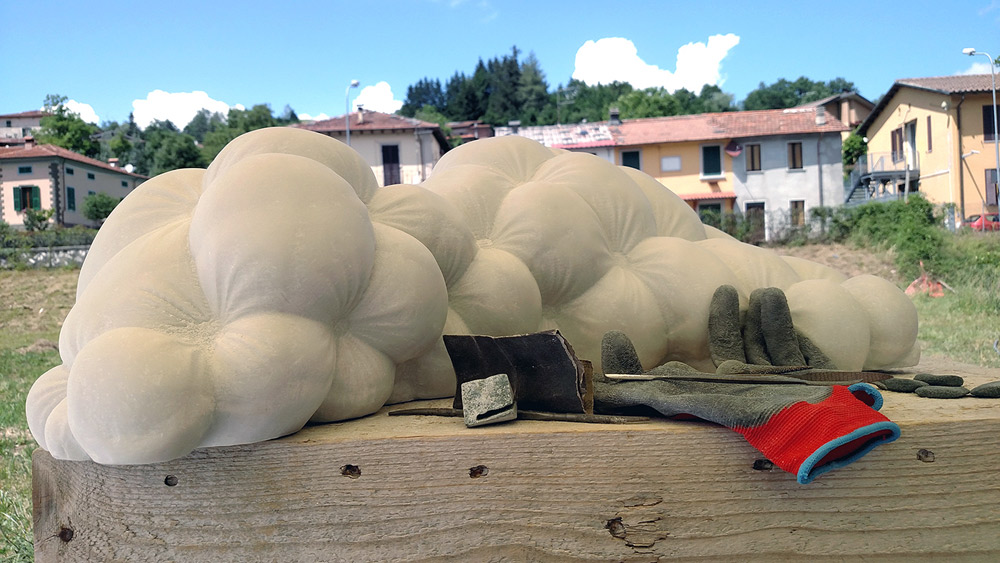Showing the sculpture being hand-finished by the artist
