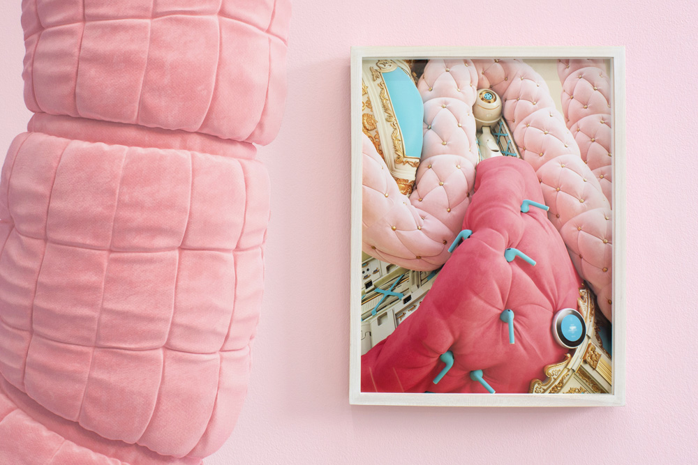 Wall decal features electronic devices juxtaposed near colorful fabrics.